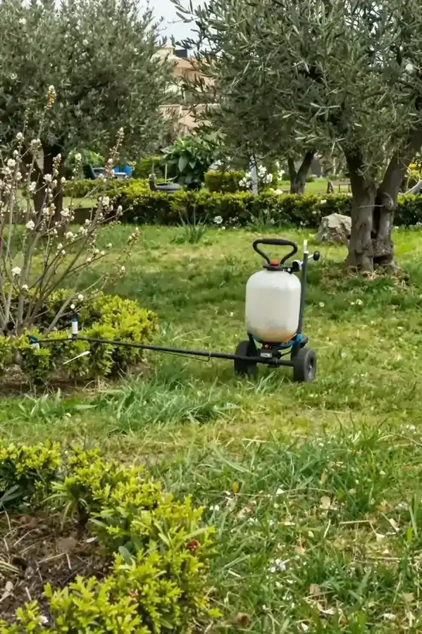 Κήπος την άνοιξη με νέα βλάστηση και εξοπλισμό λίπανσης