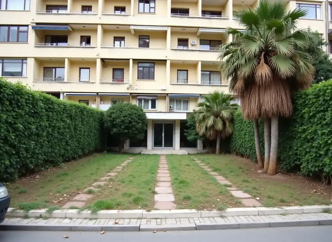 Κοινόχρηστος χώρος πολυκατοικίας στη Γλυφάδα πριν, με γυμνά σημεία στο γκαζόν και ξερά φύλλα